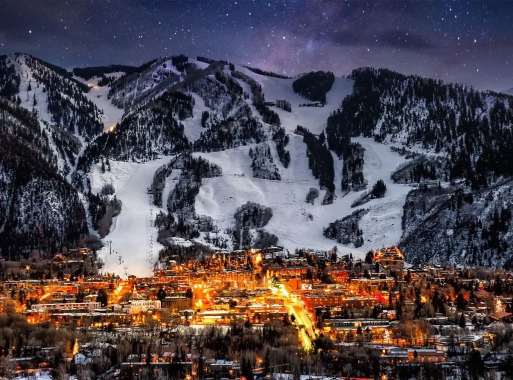 Imagem de uma cidade na beira de uma montanha coberta por neve